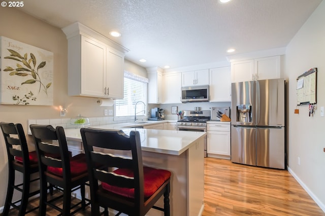 10100 NE 65th Cir, Vancouver, WA 98662 - kitchen featuring stainless steel appliances, a peninsula, white cabinets, light countertops, and recessed lighting