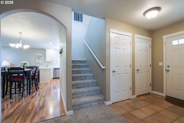 10100 NE 65th Cir, Vancouver, WA 98662 - foyer featuring a textured ceiling, a chandelier, stairway, and arched walkways