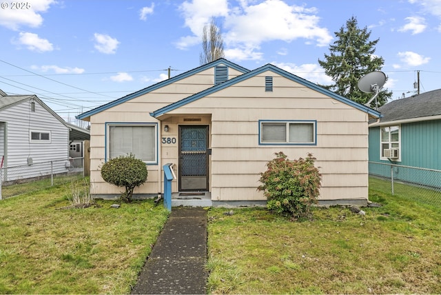 bungalow-style home with fence, a front lawn, and cooling unit