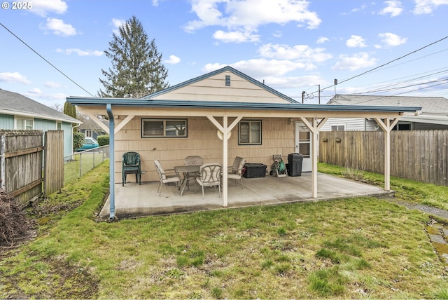 rear view of property with a fenced backyard, a patio, and a lawn