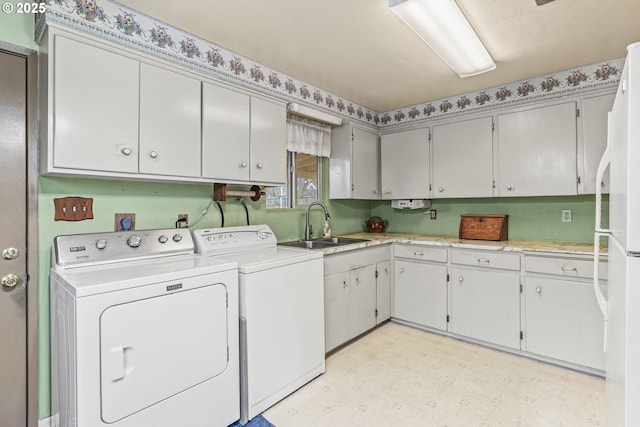 clothes washing area with light floors, washing machine and clothes dryer, a sink, and cabinet space