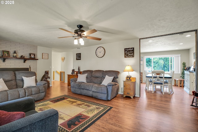 4249 SE 18th Ct, Gresham, OR 97080 - living area with wood finished floors, ceiling fan, a brick fireplace, and a textured ceiling