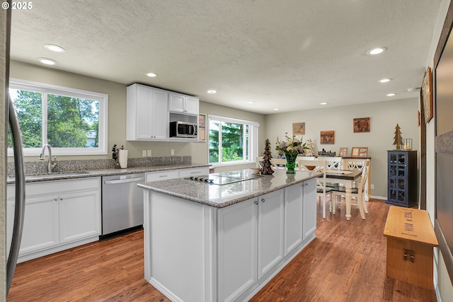 4249 SE 18th Ct, Gresham, OR 97080 - kitchen with stainless steel appliances, a textured ceiling, recessed lighting, wood finished floors, and white cabinets
