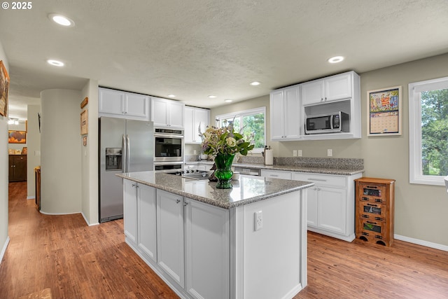 4249 SE 18th Ct, Gresham, OR 97080 - kitchen with appliances with stainless steel finishes, white cabinets, light wood-style floors, recessed lighting, and a textured ceiling