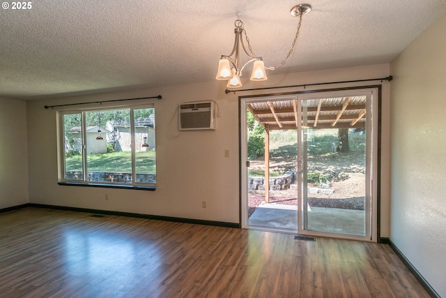 5310 Green Valley Rd, Oakland, OR 97462 - unfurnished dining area with a wall unit AC, wood finished floors, a textured ceiling, a chandelier, and baseboards
