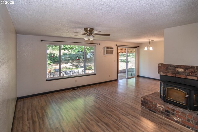 5310 Green Valley Rd, Oakland, OR 97462 - unfurnished living room featuring wood finished floors, a wall unit AC, healthy amount of natural light, and a textured ceiling