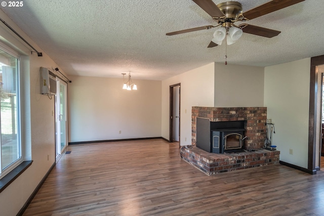 5310 Green Valley Rd, Oakland, OR 97462 - unfurnished living room featuring a textured ceiling, wood finished floors, ceiling fan, a wood stove, and baseboards