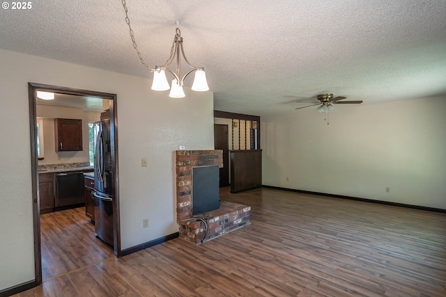 5310 Green Valley Rd, Oakland, OR 97462 - unfurnished living room featuring a textured ceiling, dark wood-type flooring, ceiling fan, baseboards, and a chandelier