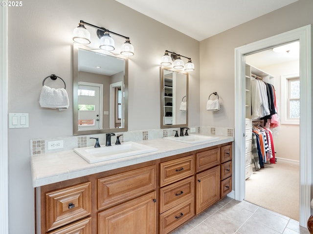 full bath featuring plenty of natural light, a sink, and double vanity