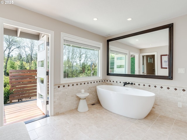bathroom featuring tile walls, tile patterned flooring, and a wainscoted wall