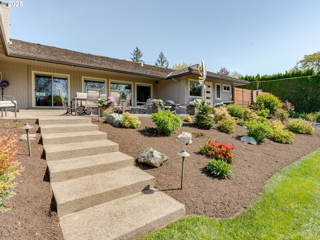 rear view of property featuring brick siding and a patio