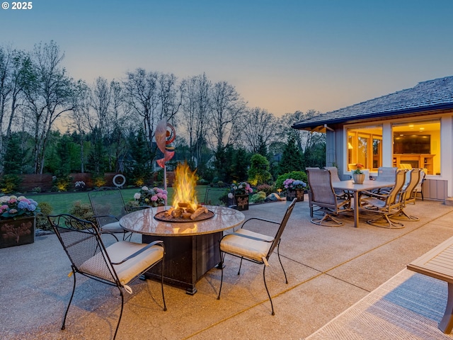 patio terrace at dusk featuring an outdoor fire pit and outdoor dining space