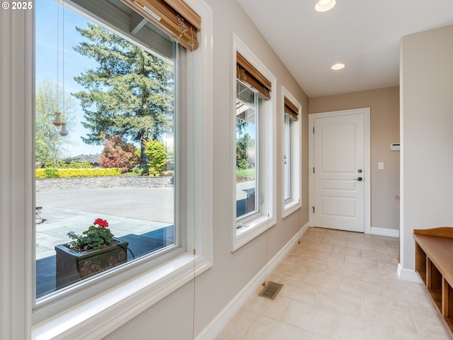 doorway to outside featuring visible vents, recessed lighting, baseboards, and light tile patterned floors