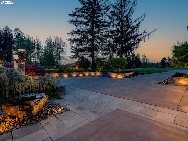 pool at dusk featuring a patio