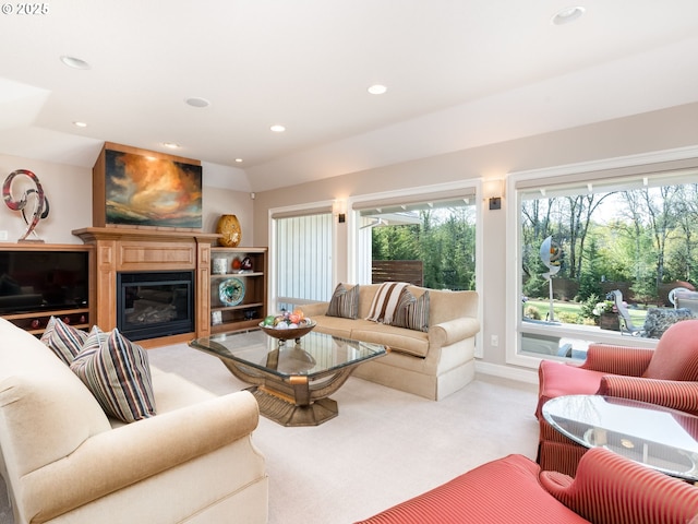 living room with a glass covered fireplace, baseboards, recessed lighting, and light colored carpet