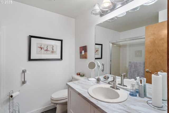 bathroom featuring vanity, toilet, and a shower with shower door