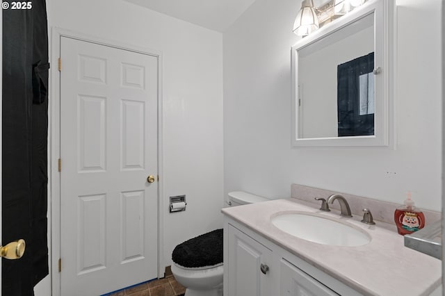 bathroom with toilet, vanity, and tile patterned floors