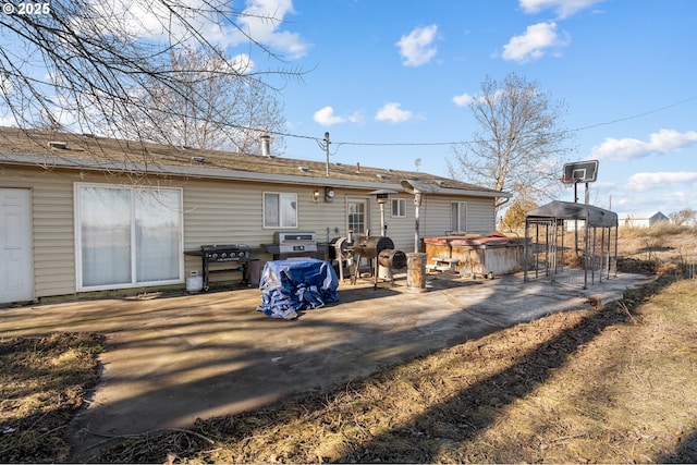 back of property with a gazebo and a hot tub