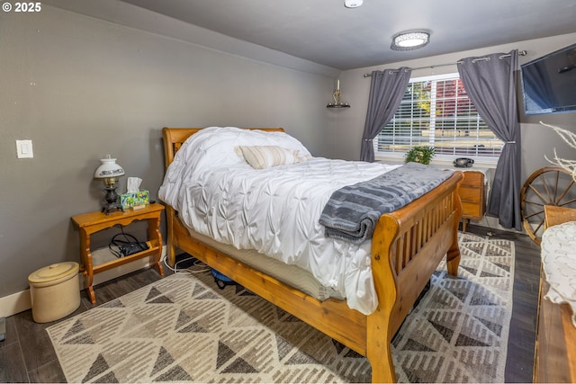 bedroom featuring wood finished floors and baseboards