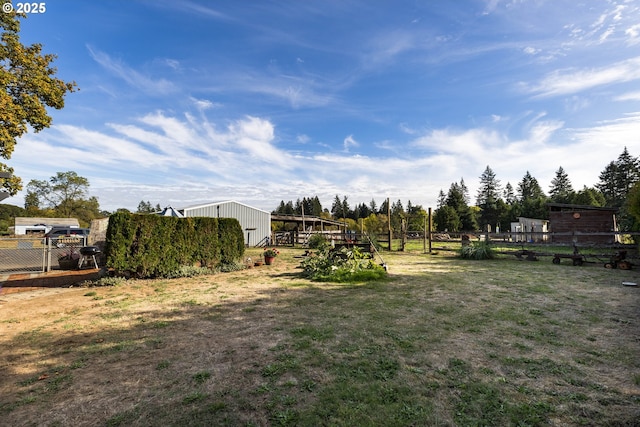 view of yard with a pole building, fence, and an outdoor structure