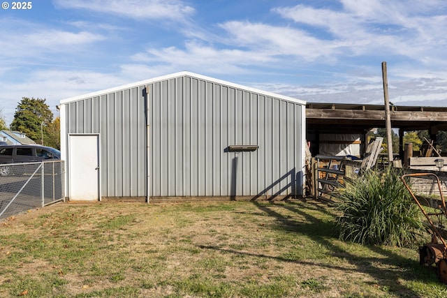 view of pole building with fence and a lawn