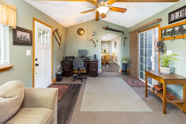 office with arched walkways, ceiling fan, vaulted ceiling, wood finished floors, and baseboards