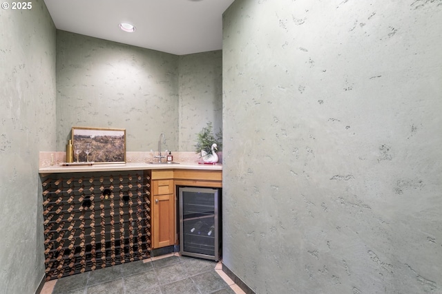 bar with wine cooler, a sink, wet bar, and light tile patterned floors