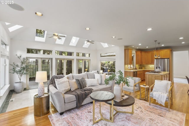 living room with light wood-type flooring, a skylight, and recessed lighting