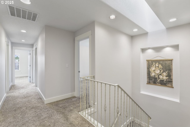 hall with recessed lighting, carpet floors, an upstairs landing, visible vents, and baseboards