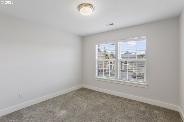 carpeted empty room with visible vents and baseboards