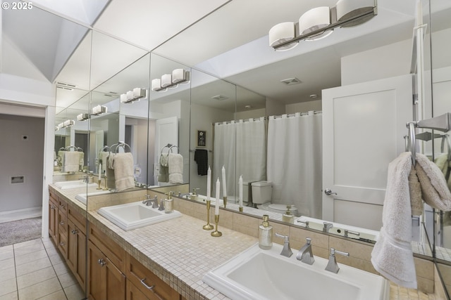 bathroom featuring tile patterned flooring, visible vents, and a sink