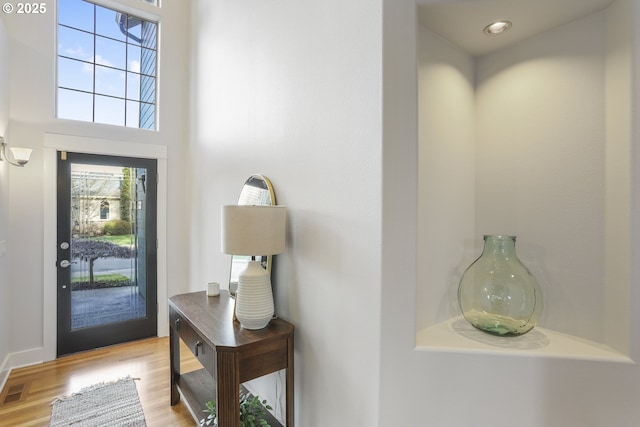 entrance foyer with a high ceiling and light wood-style flooring