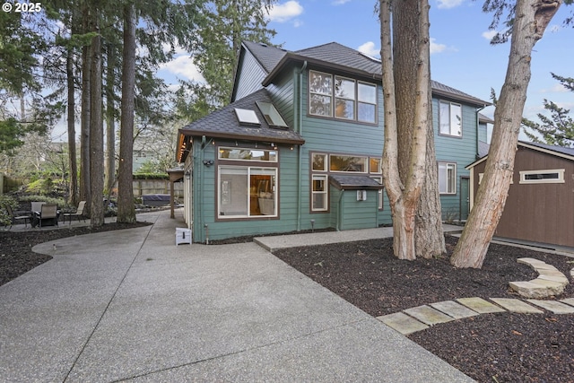 rear view of property featuring roof with shingles