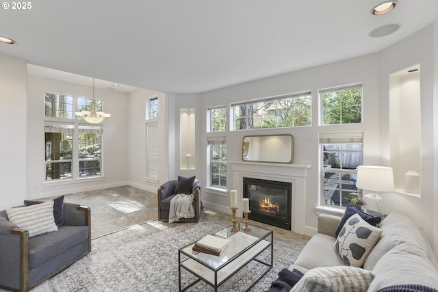 living room featuring baseboards, a wealth of natural light, and a glass covered fireplace