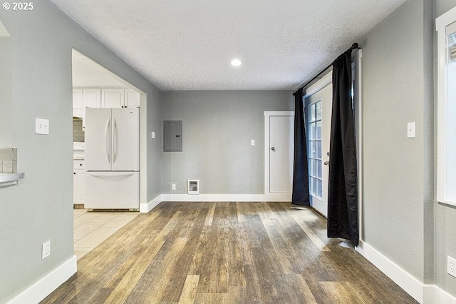 13616 SE Rhine St, Portland, OR 97236 - empty room featuring light wood-style floors, a textured ceiling, electric panel, baseboards, and recessed lighting