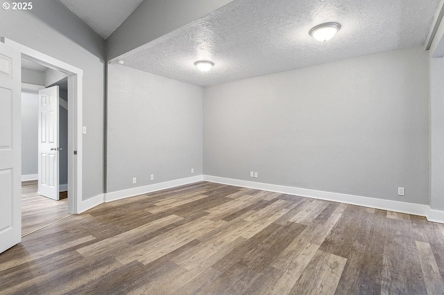 13616 SE Rhine St, Portland, OR 97236 - empty room featuring a textured ceiling, wood finished floors, and baseboards