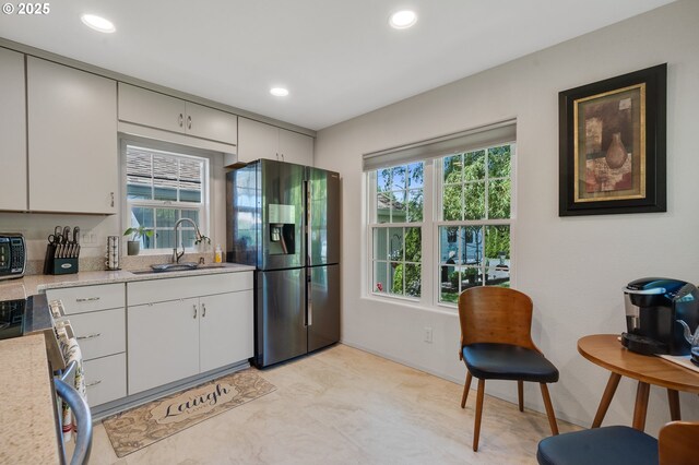 kitchen featuring appliances with stainless steel finishes, a sink, light countertops, recessed lighting, and white cabinetry
