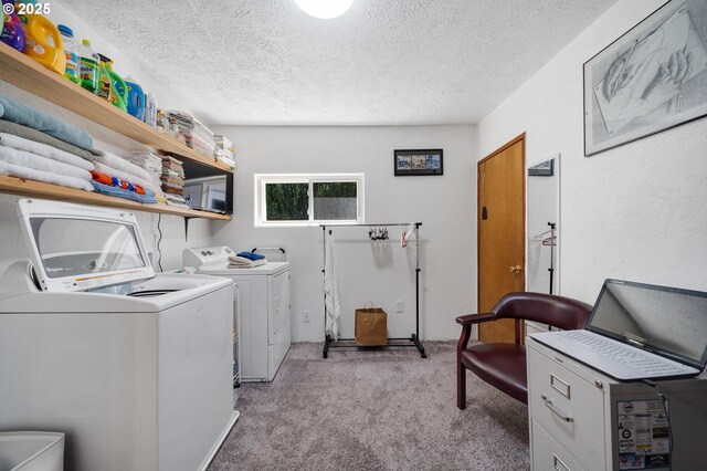 laundry room with washer and dryer, a textured ceiling, laundry area, and light carpet