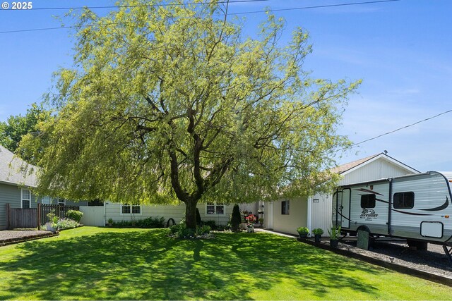 ranch-style home featuring fence and a front yard