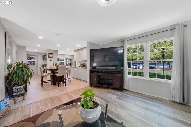 living area with recessed lighting, baseboards, and light wood finished floors