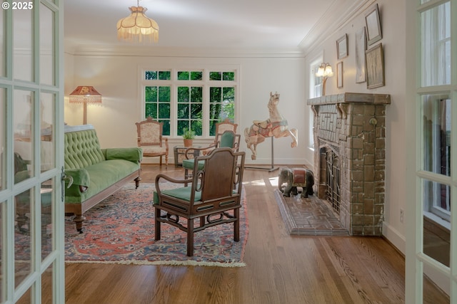 92216 Whiskey Rd, Warrenton, OR 97146 - living area featuring crown molding, wood finished floors, a fireplace with raised hearth, and baseboards