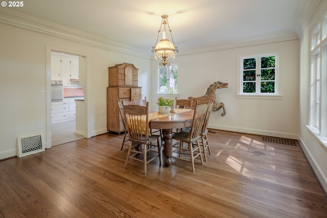 92216 Whiskey Rd, Warrenton, OR 97146 - dining space featuring crown molding, a chandelier, wood finished floors, and baseboards