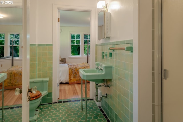 92216 Whiskey Rd, Warrenton, OR 97146 - bathroom featuring tile walls, ensuite bathroom, a wainscoted wall, and plenty of natural light