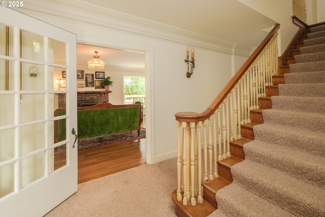 92216 Whiskey Rd, Warrenton, OR 97146 - staircase featuring crown molding, carpet flooring, a brick fireplace, and baseboards
