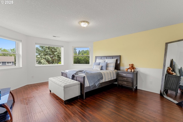 11769 SW 129th Pl, Tigard, OR 97223 - bedroom with multiple windows, dark wood-style floors, a textured ceiling, and baseboards