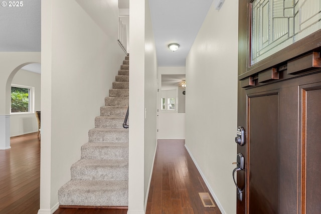 11769 SW 129th Pl, Tigard, OR 97223 - foyer with arched walkways, dark wood-style floors, stairway, and baseboards