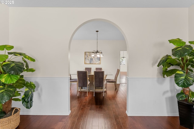 11769 SW 129th Pl, Tigard, OR 97223 - dining space featuring arched walkways, a chandelier, dark wood-style flooring, and baseboards