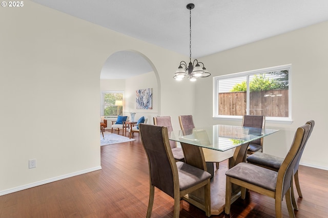 11769 SW 129th Pl, Tigard, OR 97223 - dining space featuring arched walkways, a chandelier, wood finished floors, and baseboards