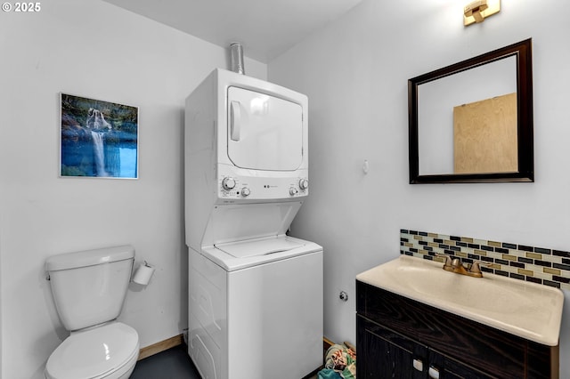 154 NE Tari Ln, Stevenson, WA 98648 - bathroom with estacked washer and dryer, toilet, tasteful backsplash, and vanity