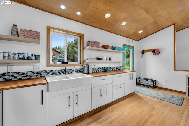 154 NE Tari Ln, Stevenson, WA 98648 - kitchen featuring butcher block counters, open shelves, a sink, vaulted ceiling, and tasteful backsplash